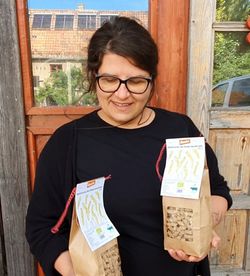 Person zeigt zwei verpackungen mit  dinkelnudeln