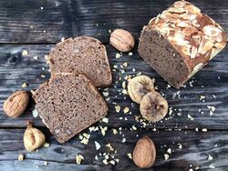 Holztisch mit Brot, Nüssen, Feigen