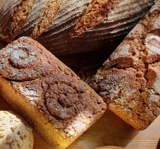 Verschiedene Sorten von rustikalem Brot liegen auf einem Holztisch.