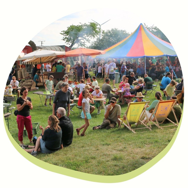 KI generiert: Ein buntes Zelt und Menschen bei einem Outdoor-Event mit Sitzgelegenheiten.