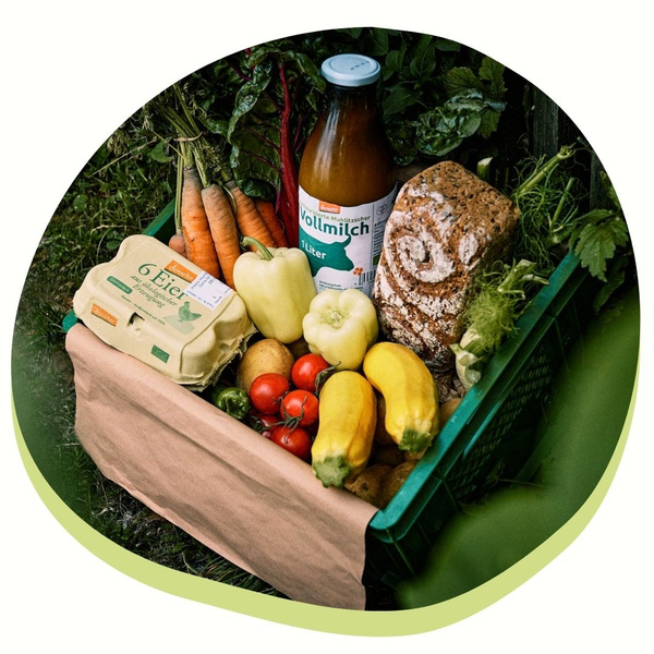 KI generiert: Das Bild zeigt einen Korb voller Lebensmittel, einschließlich Gemüse, einer Flasche Milch, Eiern und Brot. Diese Produkte vermitteln den Eindruck frischer, ländlicher Erzeugnisse.