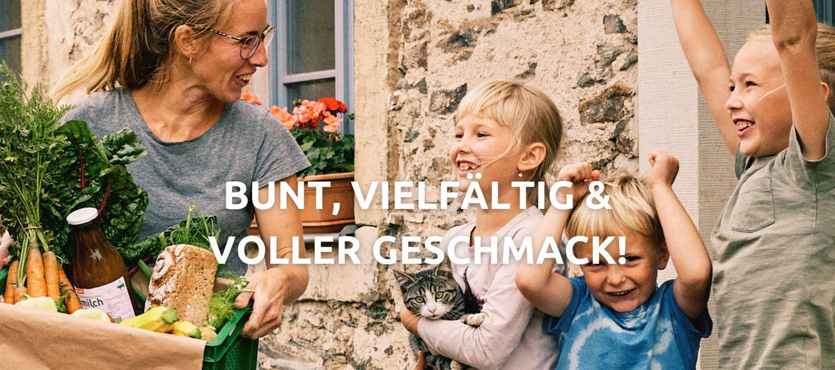 Ein Lieferfahrer stellt einer Mutter mit drei Kindern die Mahlitzscher Öko-Kiste zu, in der sich viele frische Bio-Produkte befinden.