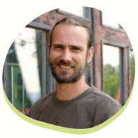 KI generiert: Eine lächelnde Person vor einem Gebäude mit Fenstern.