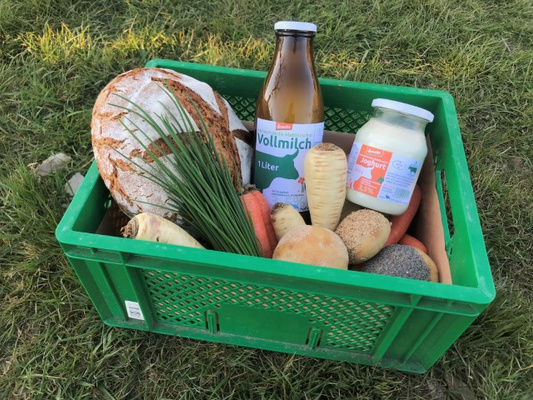Ökokiste mit Backwaren, Gemüse, Milch