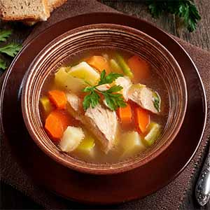 Eine Person hält eine Schale mit roten und weißen Johannisbeeren.